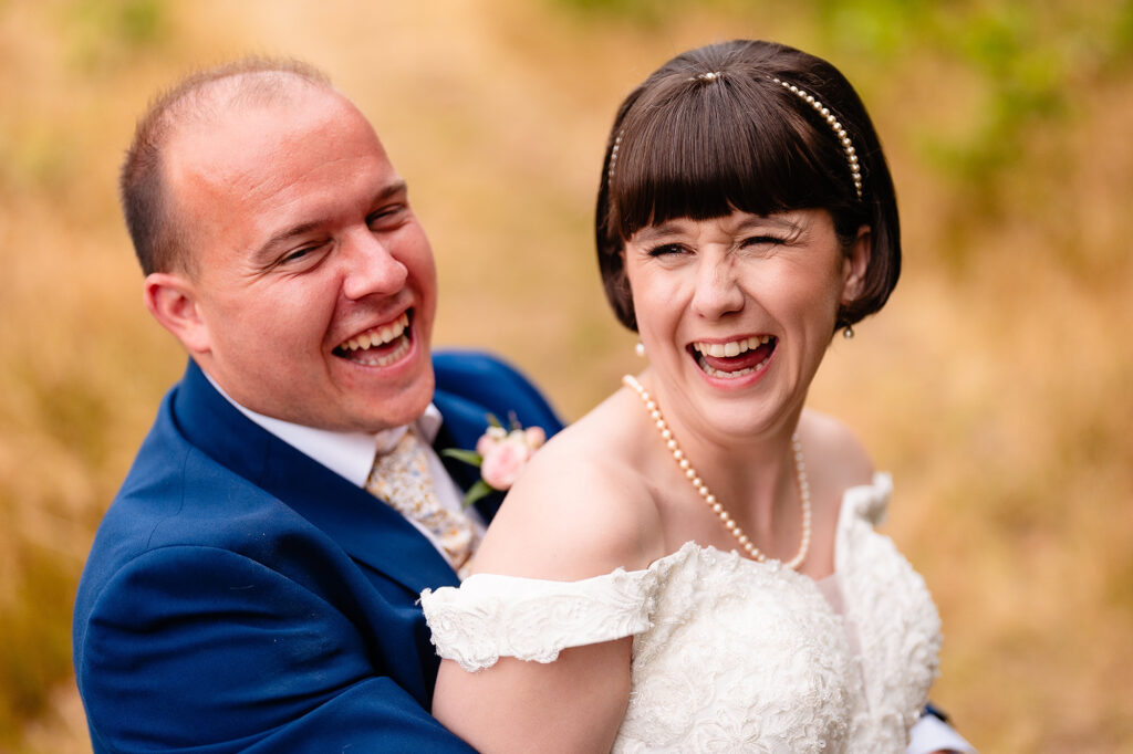 Close up of the bride and groom mid belly laugh, eyes scrunched shut