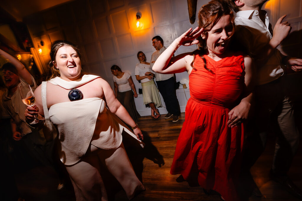 Emma dancing with a guest in a red dress