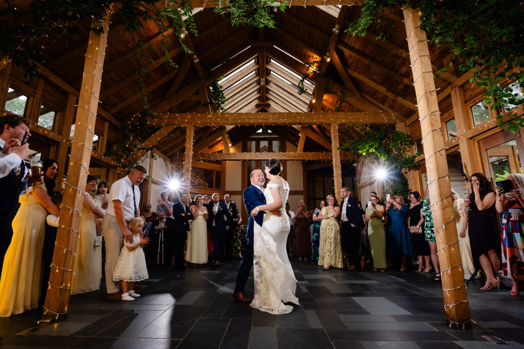 First dance under fairy lit oak beams as guests watch around the dance floor at The Oak Tree of Peover